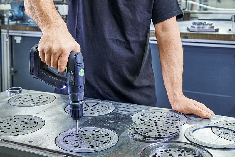 Håndværker bearbejder slibepapirplader i metal