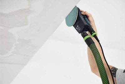 En Festool slibemaskine med bagskive i brug