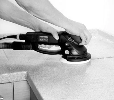 Slib først grove limsømme og fremstående materiale på mineralmaterialepladen plan