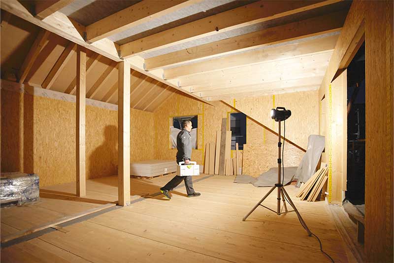 En Arbejdslampe oplyser et vinduesløst, mørkt rum