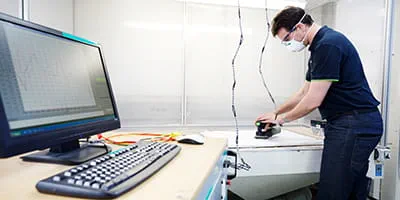 En akku slibemaskine fra Festool testes i akustikkammeret.