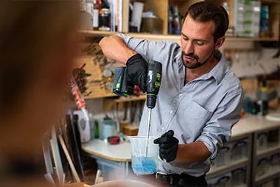Richard rører resin sammen til sit kunsthåndværk med en akku-skruemaskine