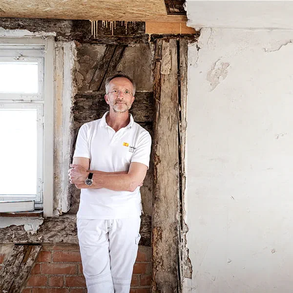 Manfred Schuler, malermester og restaurator foran væggen i det bindingsværkshus, der skal restaureres