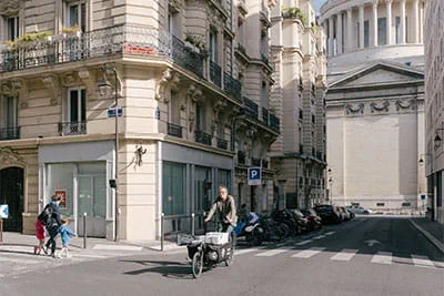 Med sin ladcykel kommer "l'ébéniste à vélo" hurtigt gennem Paris' trange bymidte; i baggrunden Panthéons berømte kuppel.