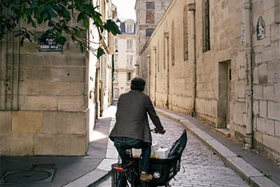 Philippe Genty sætter sig op på sin cykel, vinker venligt og kører til sin næste kunde.