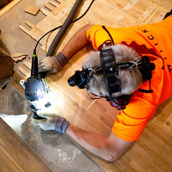 Den finske parketlægger bearbejder trægulvet med Festool overfræseren